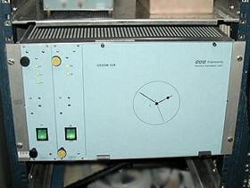 Box in a rack with switches and a clock face symbol on the front