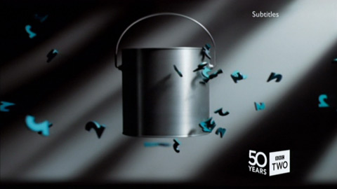 Tiny teal 2 symbols 'fall' horizontally against a grey paint bucket (23K)