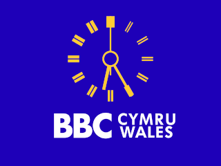 Yellow clock with white BBC CYMRU WALES lettering underneath