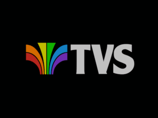 Television South ident - rainbow-coloured fleur-de-lys symbol with white TVS letters to its right